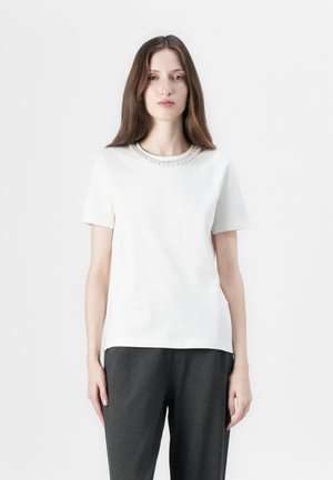 Tricou alb cu mânecă scurtă și guler rotund, ornamentat cu mici accente de pietricele transparente. Fabricat dintr-un material fin, cu o croială lejeră.