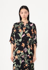 Blumenhemden in Schwarz mit orangefarbenen und grünen Pflanzenmustern, kurzärmlig und mit Kragen. Glatte Struktur.