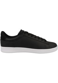 Baskets basses en cuir noir avec lacets noirs et semelle en caoutchouc blanche, vues de profil sur fond blanc.