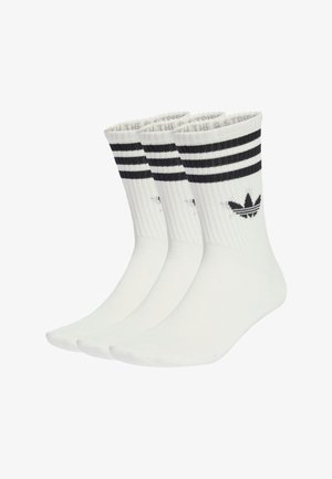 Calzini bianchi in cotone con strisce nere sulla parte superiore, caratterizzati da un logo nero e una texture a costine. Confezione da tre paia.