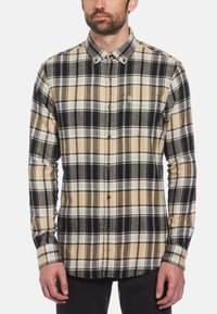 Heren overshirt met lange mouwen in beige, zwart en wit; voorzien van knoopsluiting en klein logo op de borstzak. Gemaakt van een gestructureerde stof.