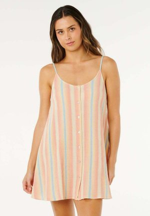 Mujer que lleva un vestido sin mangas, abotonado al frente, con rayas verticales en tonos pastel de rosa, azul y amarillo sobre un fondo claro.