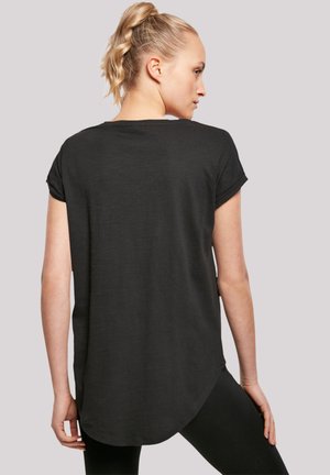 Black short-sleeve top with a curved hem, made of a lightweight fabric. Features rolled sleeves and is paired with black leggings.