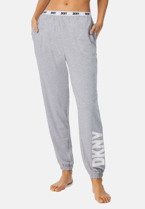 Pantalon de survêtement gris en tissu doux, avec une taille élastique portant le logo "DKNY" et des poches latérales. Ajusté au niveau des chevilles.
