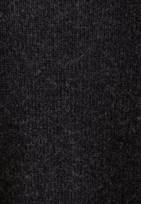 Tummanharmaa neulottu kangas, jolla on pehmeä tekstuuri ja hienovarainen, hieman pörröinen pinta. Tiukat silmukat luovat yhtenäisen ilmeen kauttaaltaan.