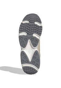 Sole boty v šedé gumě s texturovaným vzorem, který obsahuje trojúhelníkové výstupky a bílý gumový akcent. Zadní část ukazuje detail loga.
