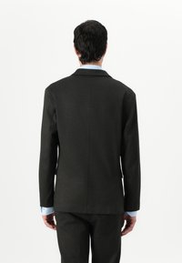 Dark gray tailored blazer with a notch lapel, single vent, and a smooth texture. Features light blue shirt cuffs peeking from the sleeves.