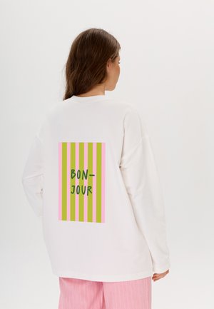 Witte sweatshirt met lange mouwen, voorzien van een rechthoekige afbeelding op de achterkant met roze, groene en gele strepen en de tekst "BON-JOUR" in het groen.