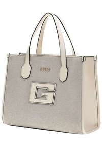 Borsa tote beige con tessuto strutturato, bordi neri a contrasto e logo dorato. Presenta doppie maniglie e un evidente emblema "G" sulla parte anteriore.
