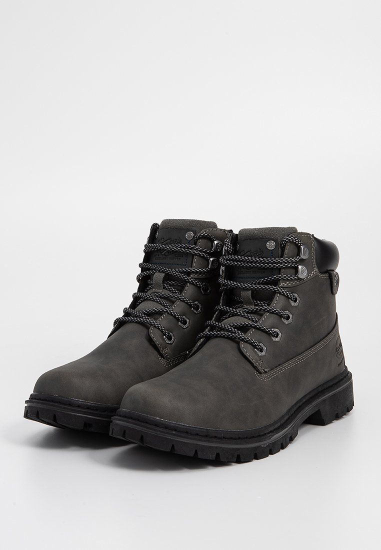 Para ciemnoszarych skórzanych botków za kostkę na sznurówki z wyściełanym kołnierzem i grubymi gumowymi podeszwami na białym tle.