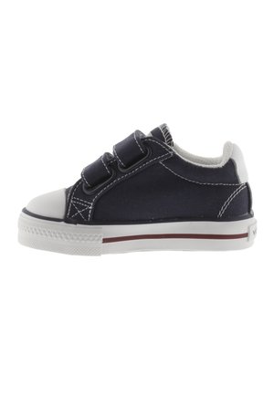 Zapatilla de lona azul marino con puntera y suela de goma blanca, dos correas de velcro y costuras blancas en contraste.