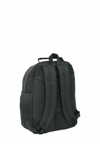 Zaino nero con design imbottito, tasca laterale in rete, spallacci resistenti e maniglia superiore per un facile trasporto. Chiusura con zip visibile sul retro.