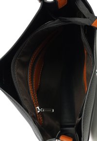 Zwarte leren handtas interieur met tan accenten, voorzien van één ritsvak en ruime compartimenten, gevoerd met zachte stof.