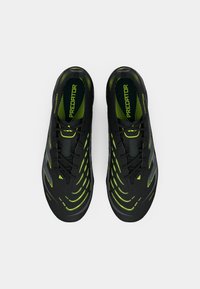 Black athletic shoes with green accents, featuring a textured upper, streamlined design, and a lace-up closure for secure fit.