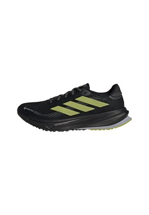 Black and yellow Adidas running shoe with Gore-Tex material, cushioned sole, and three yellow stripes on the side.