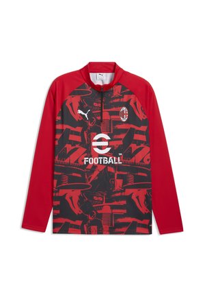 Czerwona i czarna piłkarska koszulka z długim rękawem z logo AC Milan, logo Puma, napisem eFootball oraz abstrakcyjnymi wzorami graficznymi z przodu.