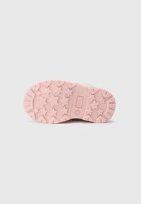Rosa gummisul med stjärnmönster, med texturerade räfflor för grepp. Platt form, designad för komfort och hållbarhet.