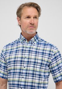Camicia a maniche corte con bottoni in un motivo tartan multicolore che presenta blu, verde e bianco. Realizzata in un tessuto leggero e traspirante.