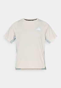 Αθλητικό κοντομάνικο μπλουζάκι σε ανοιχτό μπεζ, με τουρκουάζ πάνελ κατά μήκος των πλευρών και λευκό λογότυπο στο στήθος. Λείο υλικό.