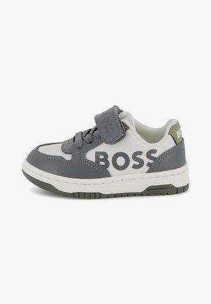 Grå och vit sneaker med mesh och syntetiska material, med en kardborrerem, framträdande "BOSS"-logo och texturerad gummisula.