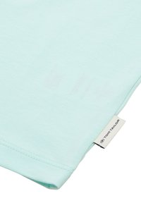 Jasnoniebieska koszulka z krótkim rękawem wykonana z miękkiego materiału, z okrągłym dekoltem i metką marki Tom Tailor wszytą u dołu.