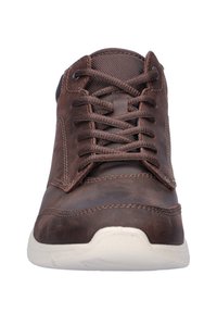 Sneaker in pelle marrone con accenti in tessuto scuro, punta rotonda e design con lacci; presenta una superficie testurizzata e una suola bianca a contrasto.