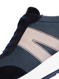Close-up of navy blue and beige sneaker with textured leather, dark laces, and white sole.