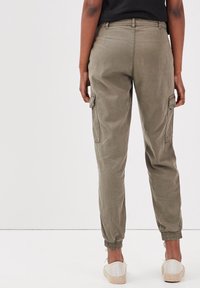 Olive green cargo pants with elastic ankle cuffs and side pockets, featuring a smooth cotton blend fabric and a relaxed fit design.