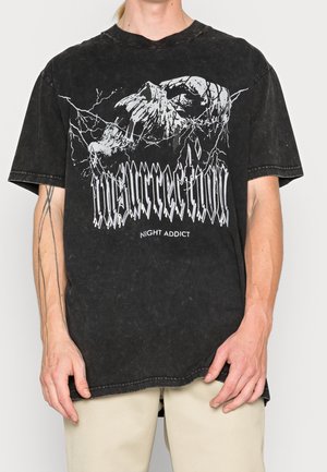 Zwart T-shirt met korte mouwen met een grafische print van een schedel en bliksem en de tekst "INSURRECTION" in gestileerde witte letters. Versleten textuur.