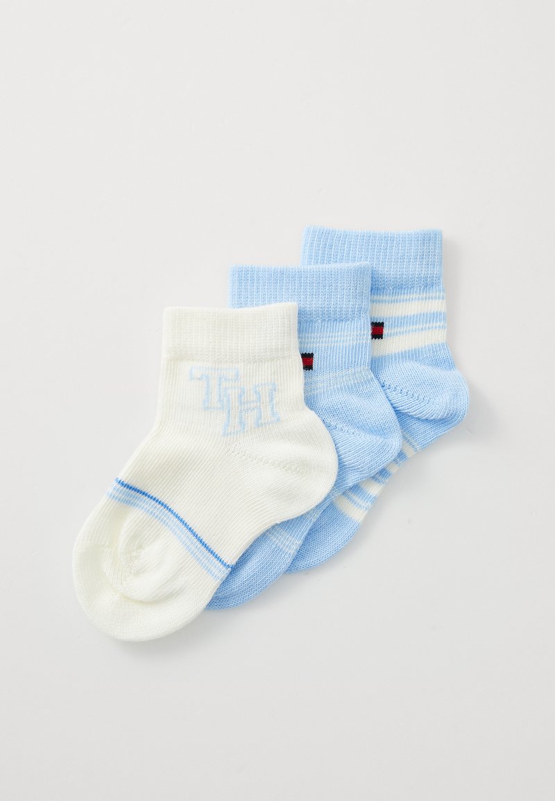 Három pár zokni: egy fehér kék részletekkel és "TH" logóval, két világoskék, az egyik csíkos, piros részletekkel. Pamut keverék anyag.