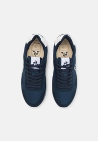 Sneaker blu navy con dettagli bianchi. Materiali in rete e sintetici. Punta arrotondata, lacci piatti e soletta imbottita con dettagli del logo.
