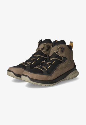 Wanderstiefel, die eine Mischung aus schwarzem Mesh und braunem Leder aufweisen, mit einer strukturierten Oberfläche, verstärkter Zehenkappe und rutschfester Gummisohle.