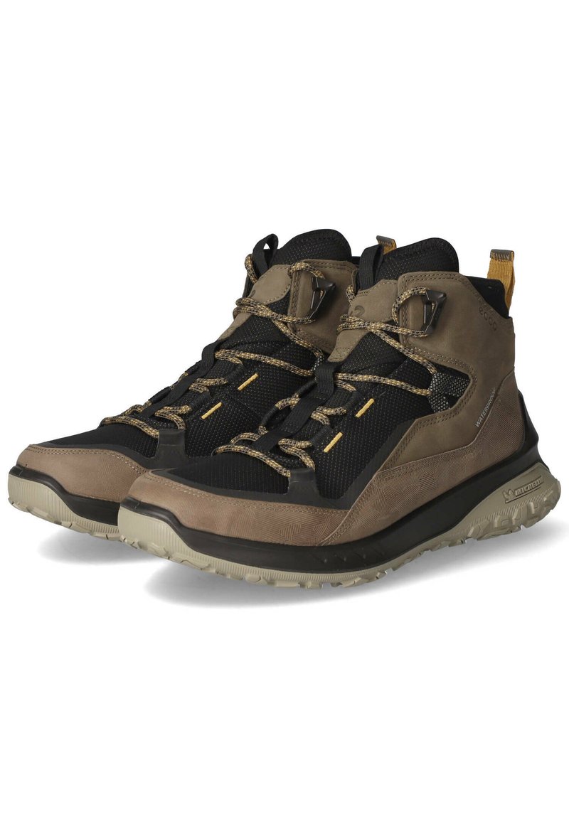 Wanderstiefel, die eine Mischung aus schwarzem Mesh und braunem Leder aufweisen, mit einer strukturierten Oberfläche, verstärkter Zehenkappe und rutschfester Gummisohle.