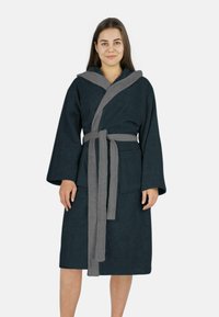 Marineblaues Bademantel mit grauem Schalkragen und Bindegürtel, aus weichem, strukturiertem Stoff. Mit langen Ärmeln und zwei vorderen Taschen.