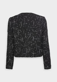 Czarna kurtka o strukturalnej fakturze z białym, nakropionym wzorem, z długimi rękawami i skróconym krojem, przedstawiona z tyłu na białym tle.