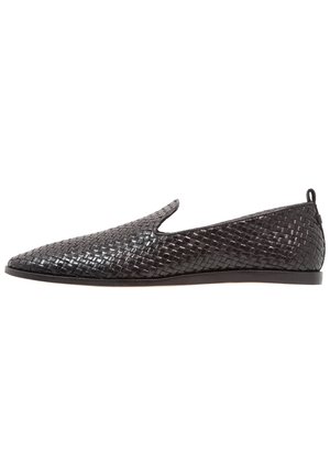 Scarpa nera in pelle intrecciata senza lacci con punta appuntita, suola bassa e piatta e piccolo tirante sul tallone sul retro.