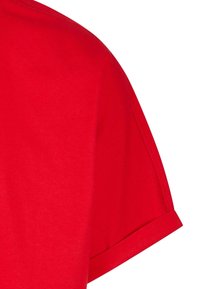 Camiseta de algodón roja con cuello redondo y mangas cortas con puños doblados, textura suave y diseño de color sólido.