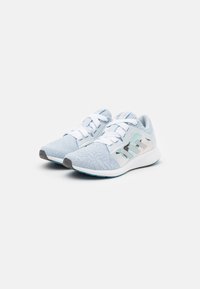 Des chaussures de sport bleu clair avec une tige texturée, des lacets blancs et un design subtil sur le côté, dotées d'une semelle en caoutchouc et d'une semelle rembourrée.
