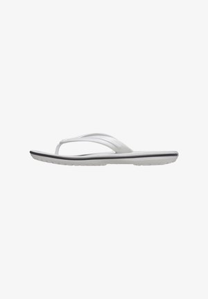 Tongs blanches en caoutchouc avec une semelle plate, des brides fines et un intérieur texturé. Présente un accent gris subtil sur le bord de la semelle.