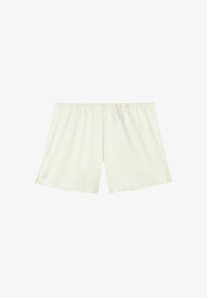 Shorts de couleur crème clair avec une taille élastique, fabriqués en tissu doux, présentant une coupe droite et des fentes latérales pour plus de liberté de mouvement.