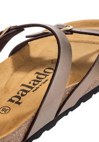 Brune læder flip-flop sandal med to stropper, guldfarvet hardware og en struktureret korkindsats. Har en sort gummisål.