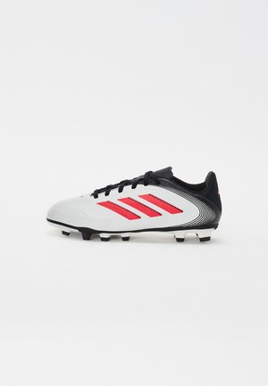 Bottine de football blanche, noire et rouge. Présente trois bandes rouges, des lacets et une tige texturée. Semelle noire avec des crampons moulés pour l'adhérence.