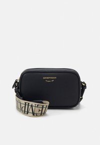Sort læder crossbody-taske med lynlåslukning, med en guldlok og en aftagelig stofrem med trykt detalje.