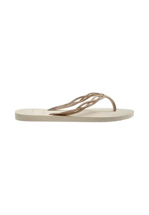 Sandalia plana beige tipo flip-flop con suela texturizada y tiras retorcidas metálicas en color oro rosa.