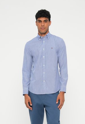 Blau-weiß gestreifte Hemd mit Button-Down-Kragen und kleinem Logo auf der Brust. Hergestellt aus leichtem Stoff mit glatter Textur.