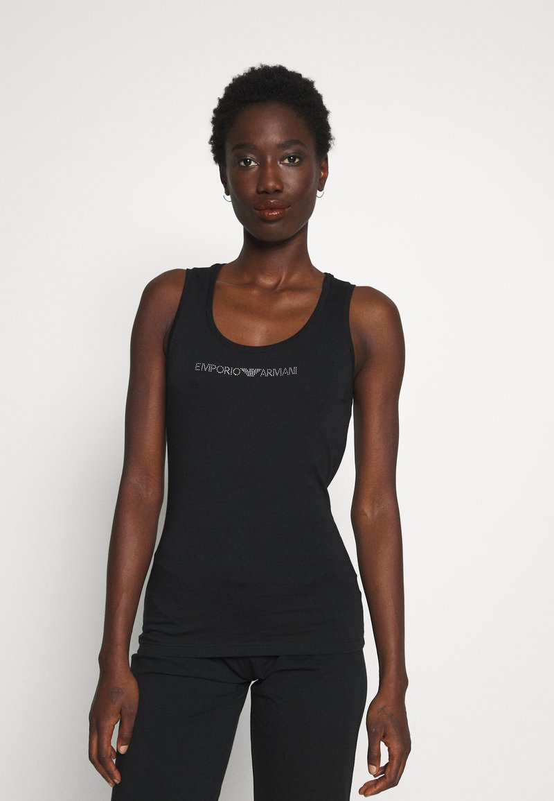 Camiseta sin mangas negra hecha de tela suave, con un logo plateado en el pecho. Ajustada, con escote redondo y sin adornos.