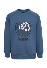 Niebieski sweter z żeberkowym dekoltem i mankietami. Posiada czarno-białą grafikę koszykówki oraz napisy "1923" i "hummel SPORTSWEAR."