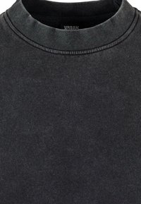 Felpa grigia scura con colletto rotondo, realizzata in tessuto di cotone. Presenta una texture morbida e cuciture sottili lungo il collo.