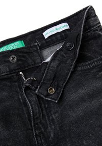 Černé džínové kalhoty z denimu s částečně rozepnutým zipem a knoflíkovou légu, s nápisy značek „United Colors of Benetton“ a „Michael Balloon“.