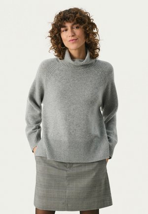 Grå turtleneck sweater med ribbet kant og manchetter, der har en blød striktekstur. Sammen med en grå ternet nederdel.